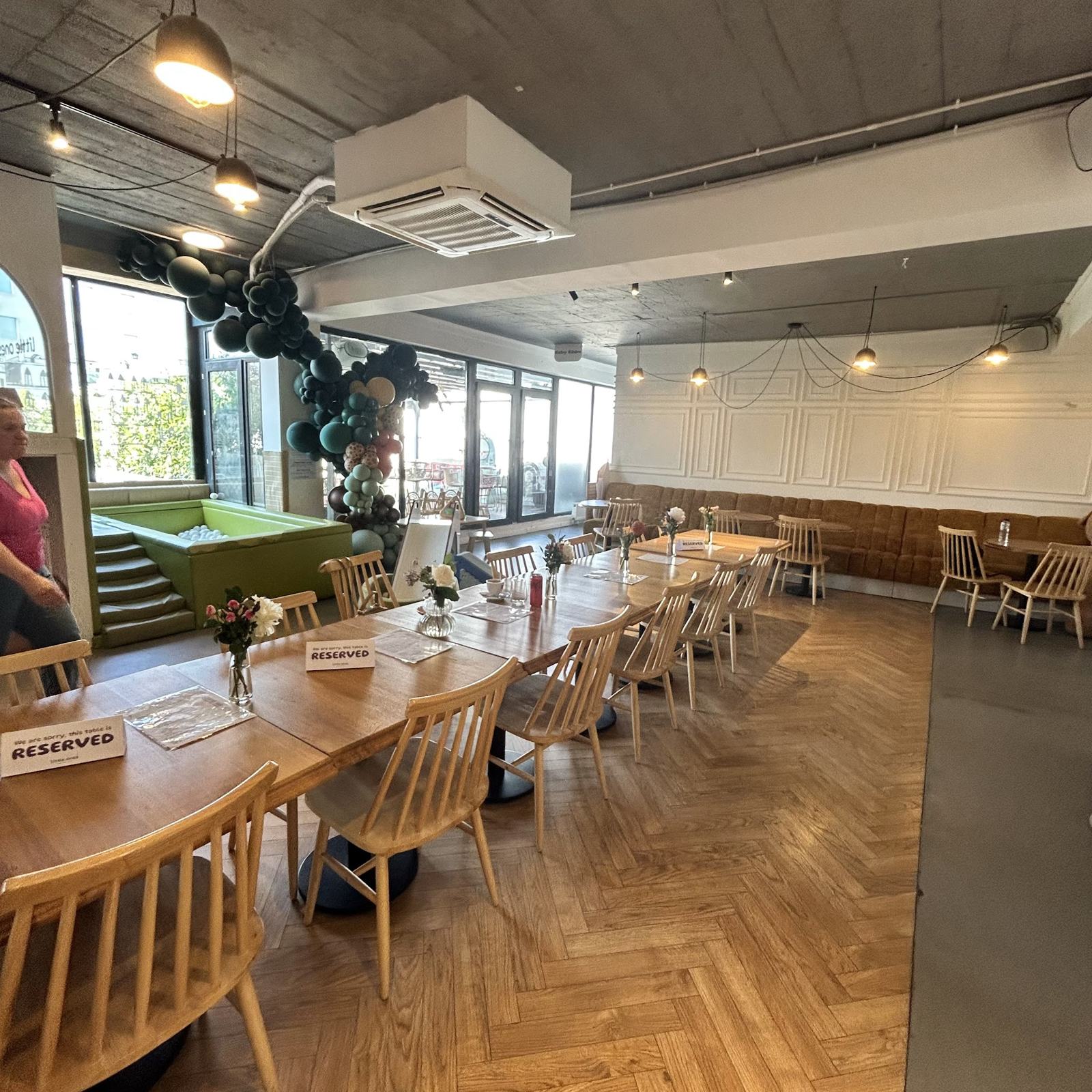 Mesele cafenelei pentru părinți, lângă ferestrele mari